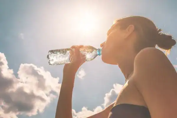 Hydration: The Secret Ingredient for a Toned Stomach and Enhanced Fitness 3 Image of woman drinking water to hydrate St Albans after run.